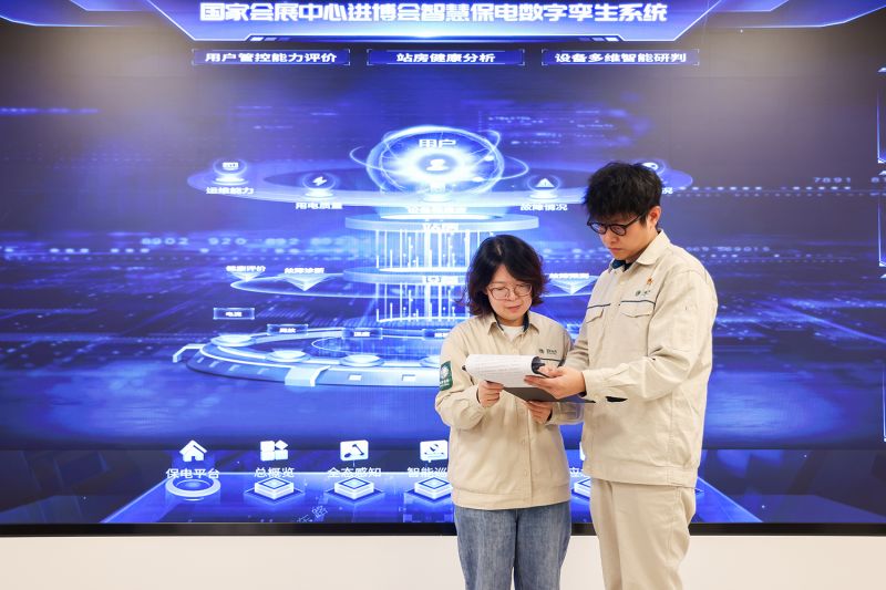 國(guó)網(wǎng)上海青浦供電公司客戶經(jīng)理趙斯韋、趙方芳在進(jìn)博會(huì)現(xiàn)場(chǎng)指揮中心，依托數(shù)字孿生智慧保電系統(tǒng)開(kāi)展安全用電檢查工作。